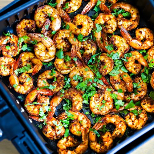 A pile of air fryer shrimp on a white plate.