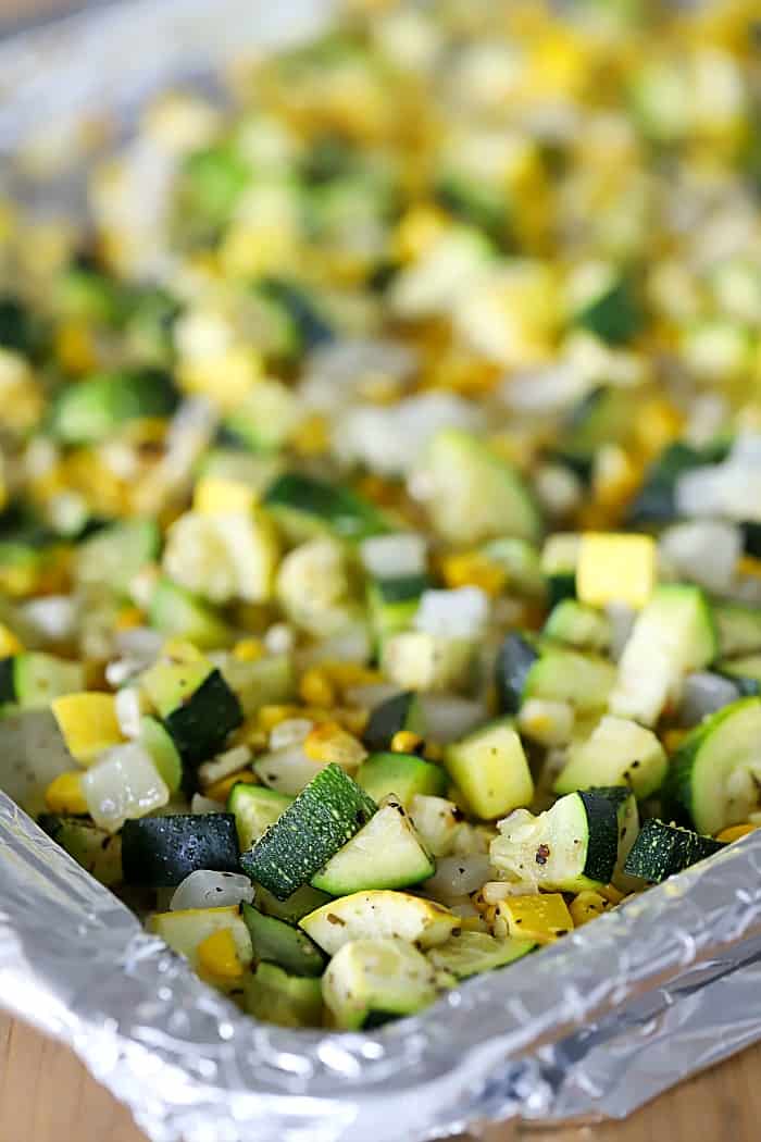 Sheet pan with roasted zuchinni, squash, garlic and onion.