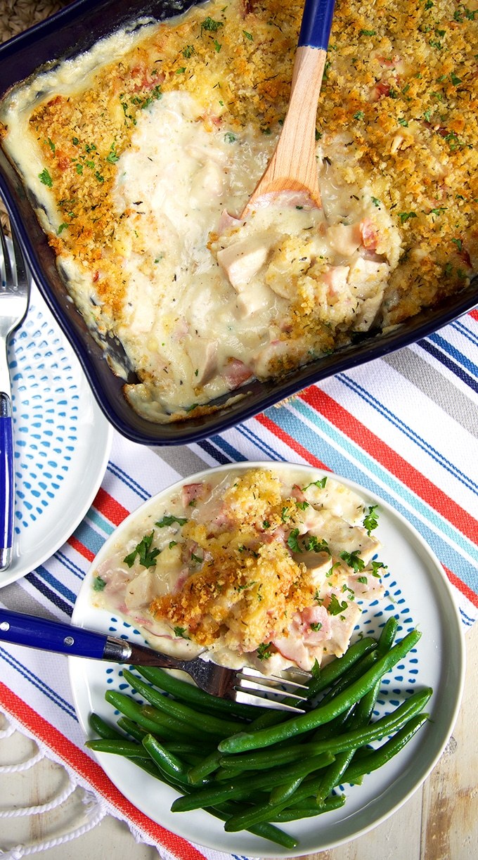 A bowl of chicken cordon bleu casserole scooped from a casserole dish beside it.