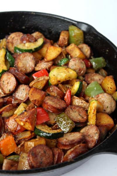 Cast Iron skillet filled with a mixture of chicken sausage and vegetables.