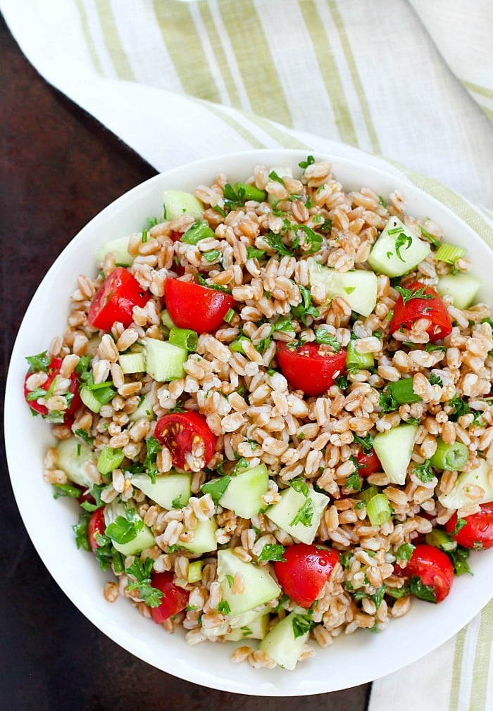 Farro Salad full of tender farro, tomatoes, cucumber, green onions, parsley, and tossed in an olive oil & lemon dressing. Super easy and delicious side dish! With a delicious mix of flavors and textures - I will be making this farro salad again and again and again. :)