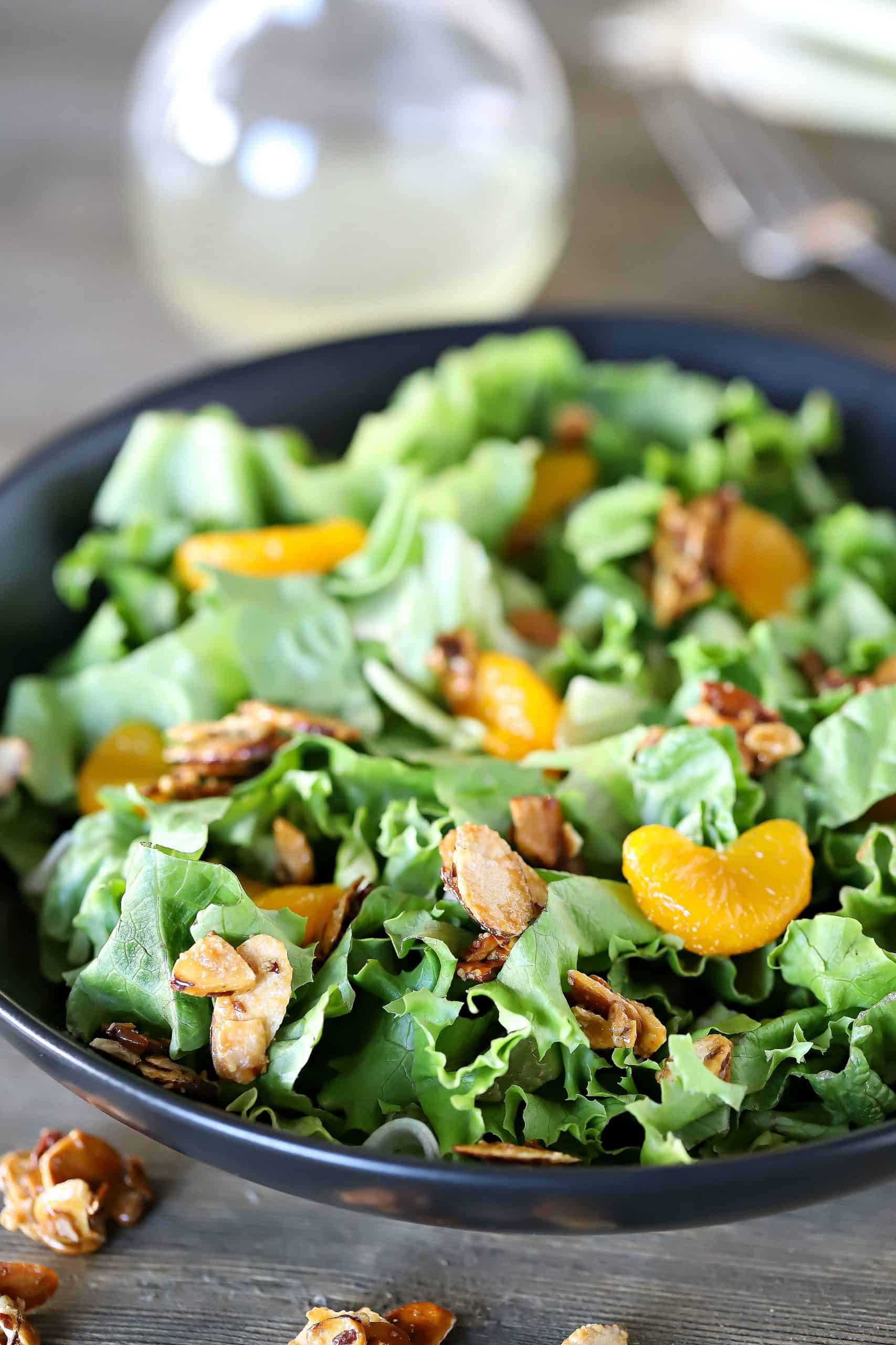 Bowl filled with lettuce mix, and topped with mandarin oranges and toasted almonds.