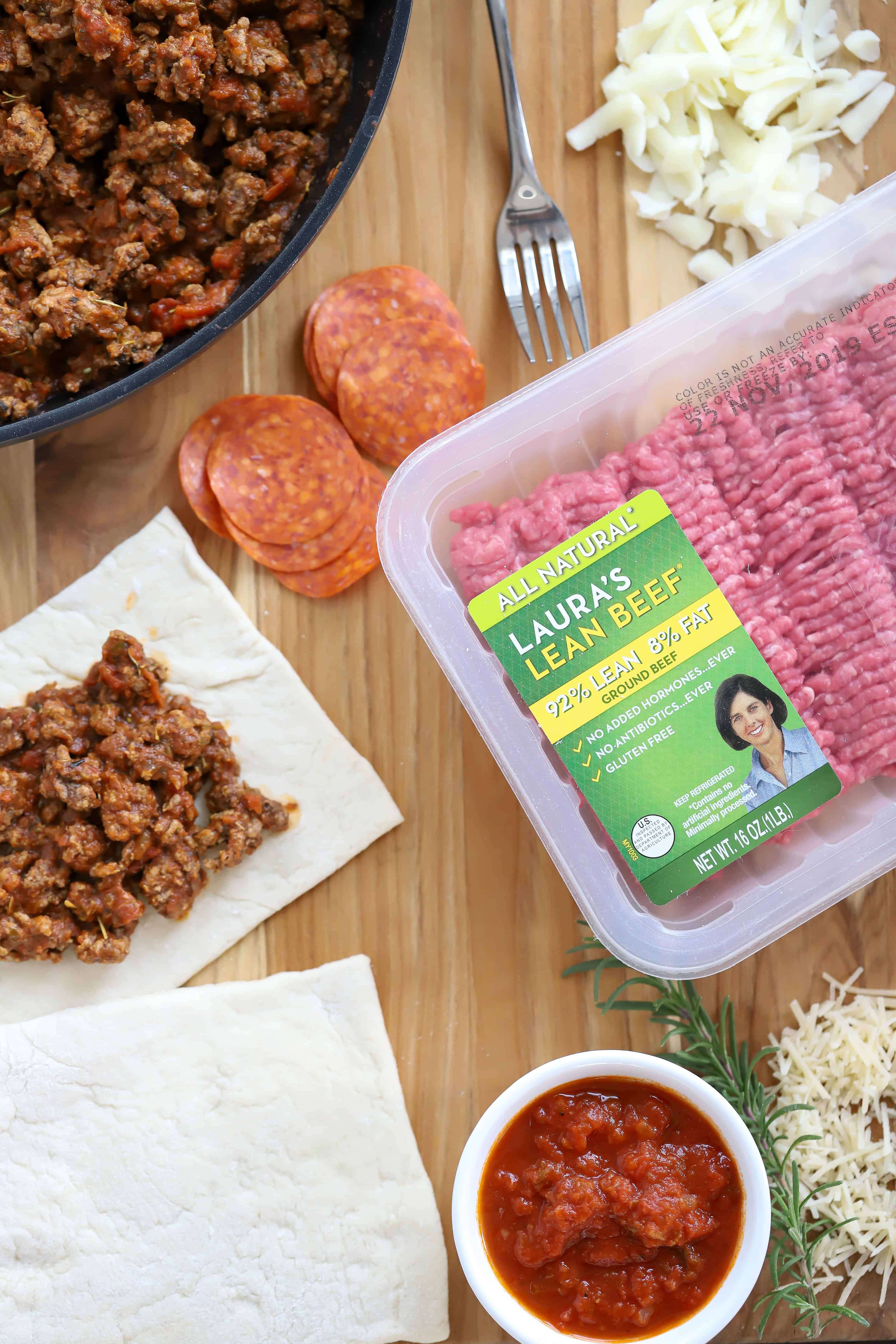Overhead shot of Laura's Ground Beef, pizza dough, pizza sauce, cheese and ground beef mixture. #ad