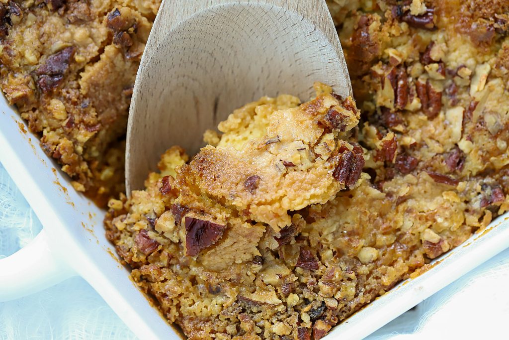 Rectangle casserole dish with a wooden spoon getting a scoop out.