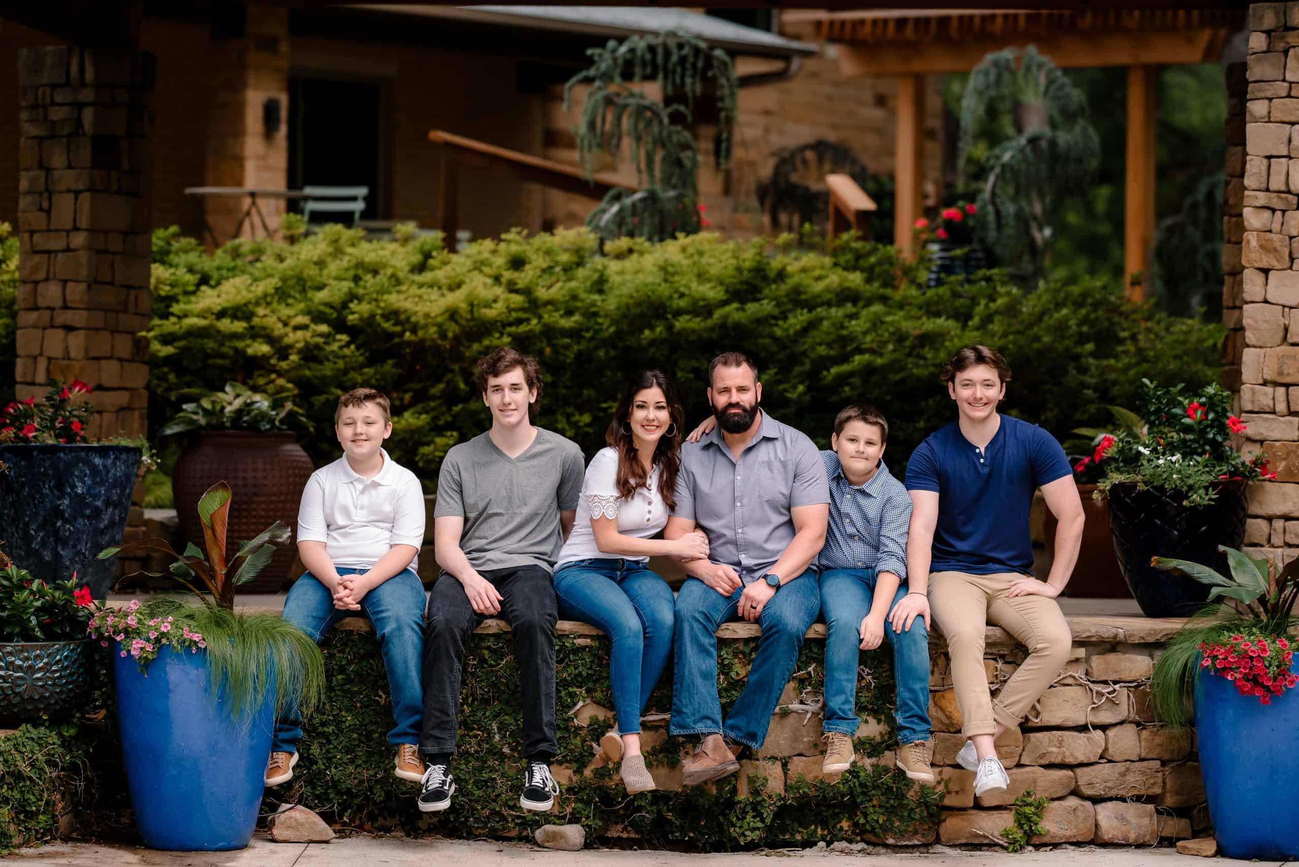 Jen Nikolaus and Family sitting on a brink wall