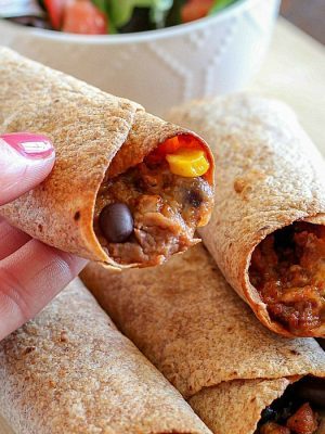 Need a light & easy dinner? Try this Skinny Baked Mexican Flautas Recipe! They're made lighter with a few ingredient swaps and are baked instead of fried. They are incredibly delicious! Whole Wheat tortillas filled with lean ground turkey, corn, black beans, refried beans, cheese, and lots of spices!! Super yummy dinner recipe!