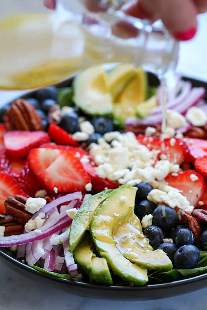 This is my favorite summer Spinach Salad Recipe! Leaves of spinach topped with berries, avocado, feta cheese, walnuts and a homemade honey-garlic vinaigrette!