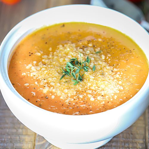 Bowl of soup topped with herbs.
